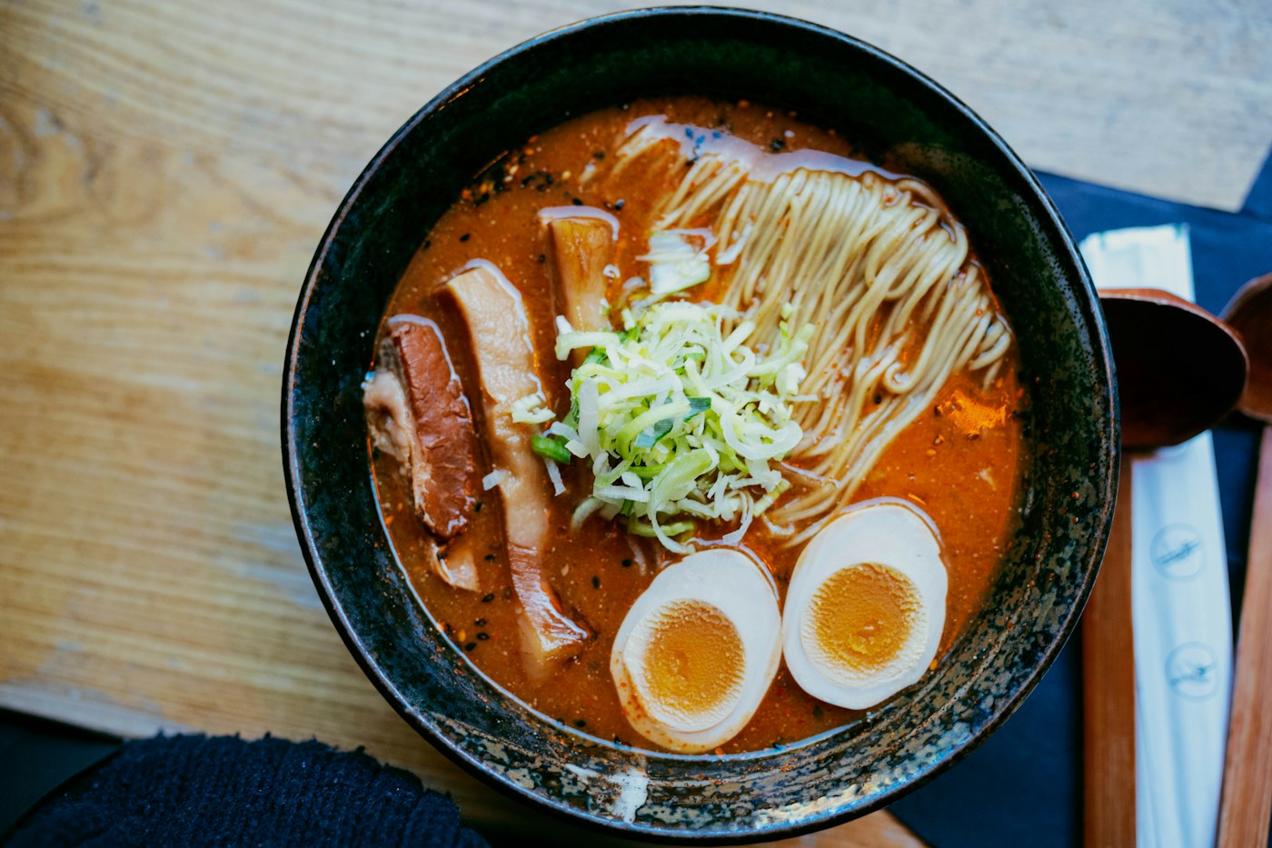 A bowl of ramen with eggs and scallions