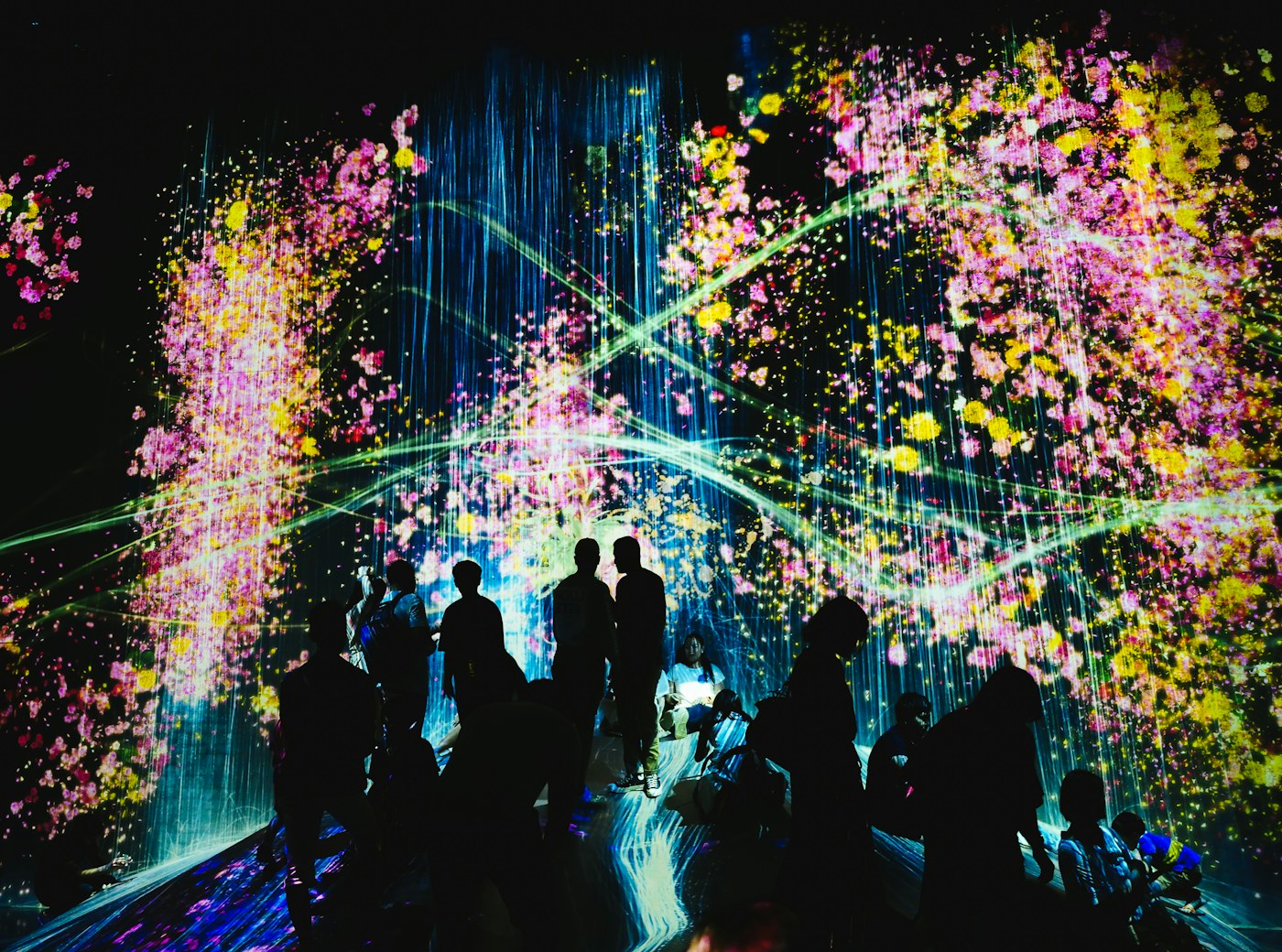 Visitors surrounded by projected light at teamLab Borderless