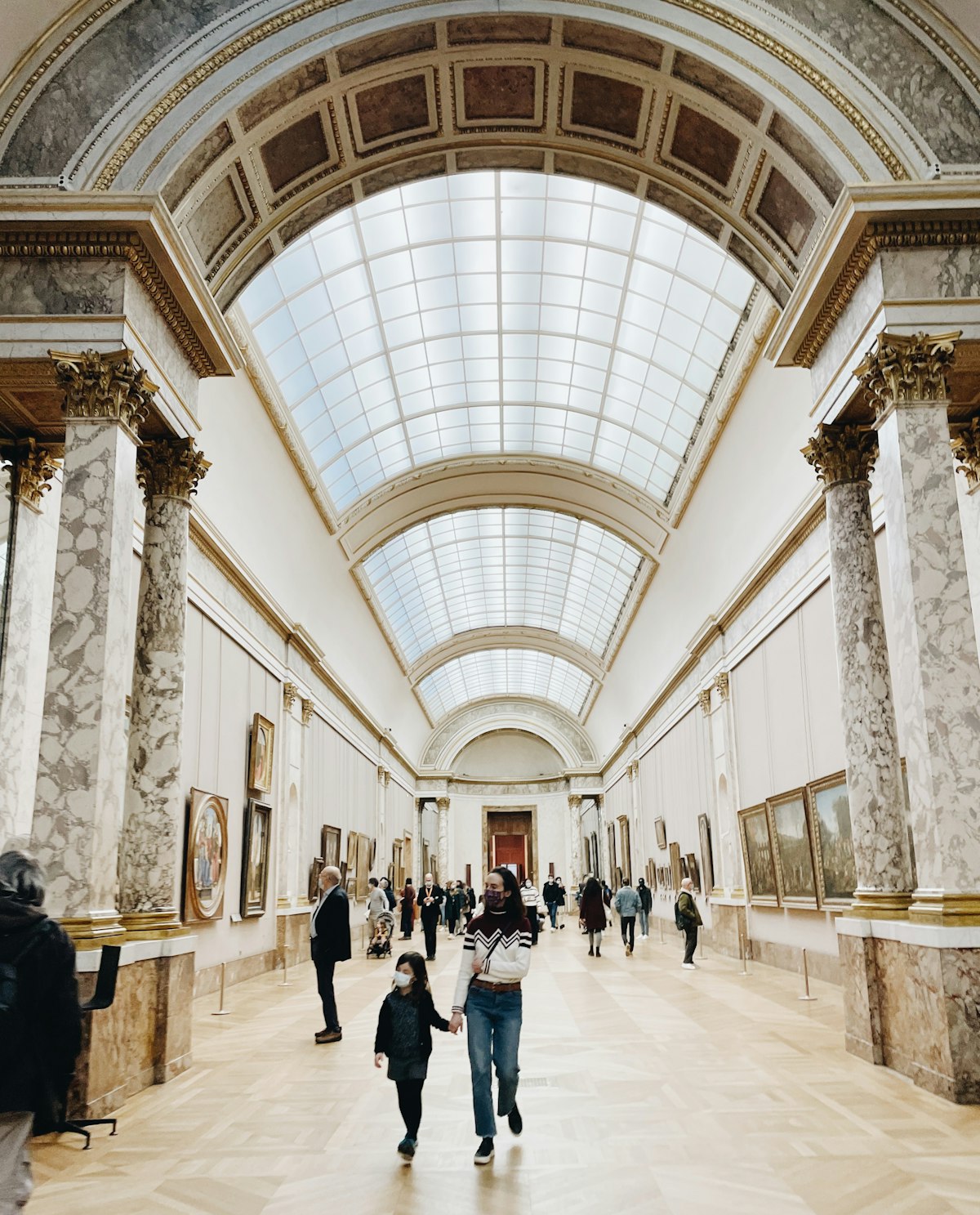 Visitors viewing paintings in a Paris museum
