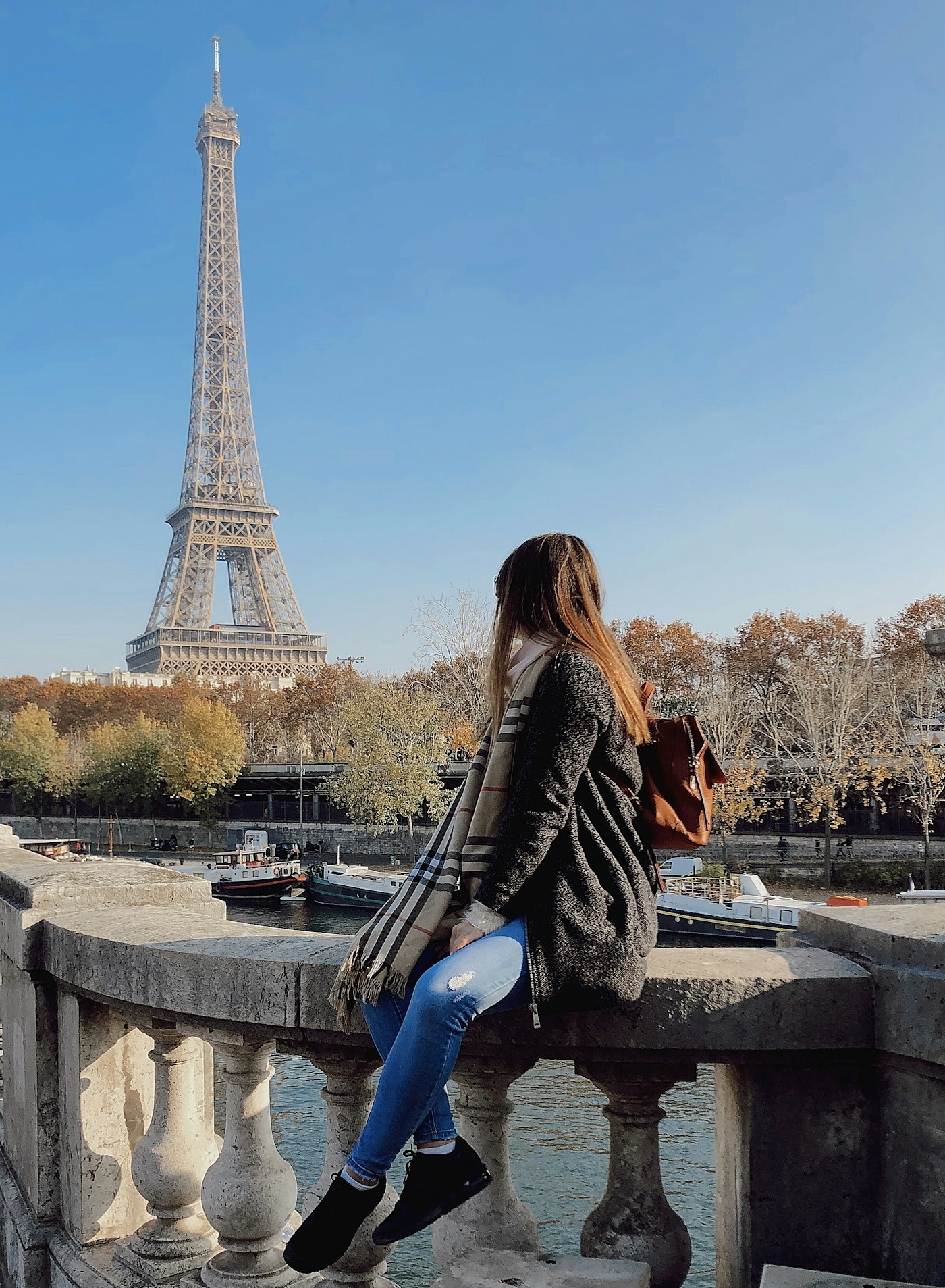A visitor beside the Seine with the Eiffel Tower beyond